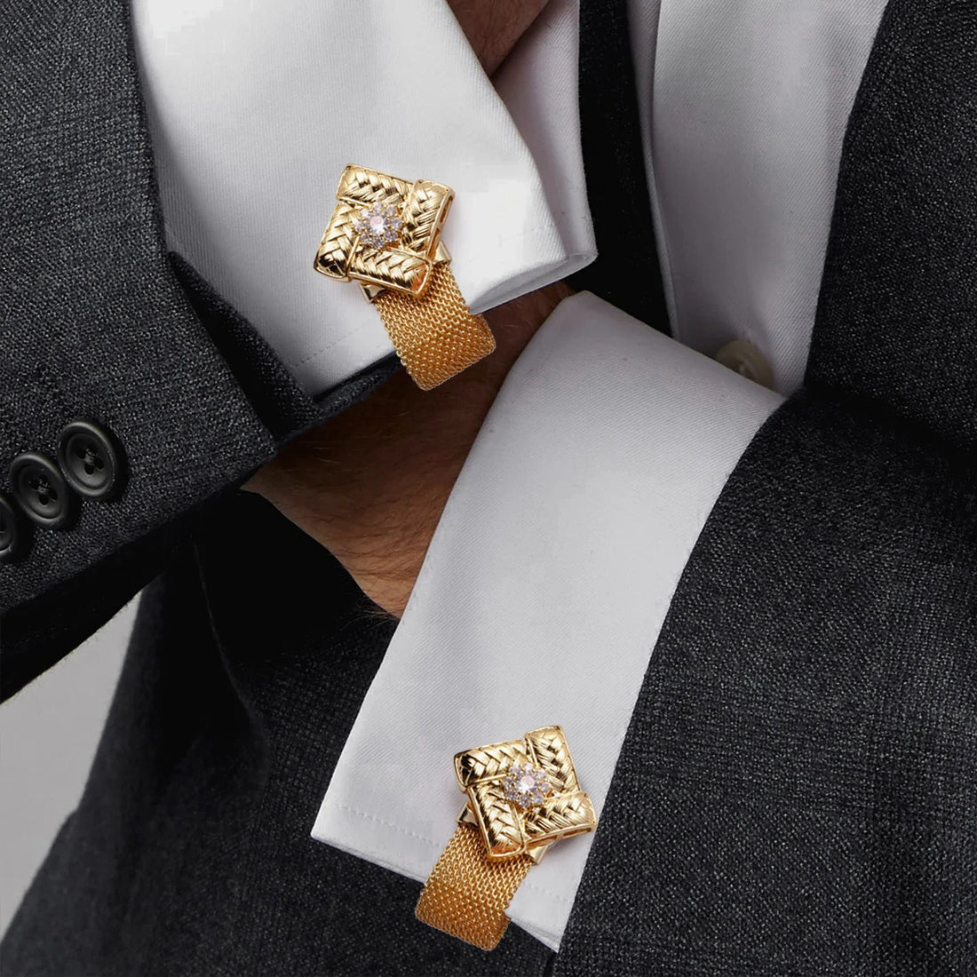 Boutons de manchette dorés posés sur une chemise blanche de marié
